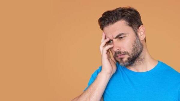 Homem com a mão sobre a cabeça representando alguém cansado ou estressado