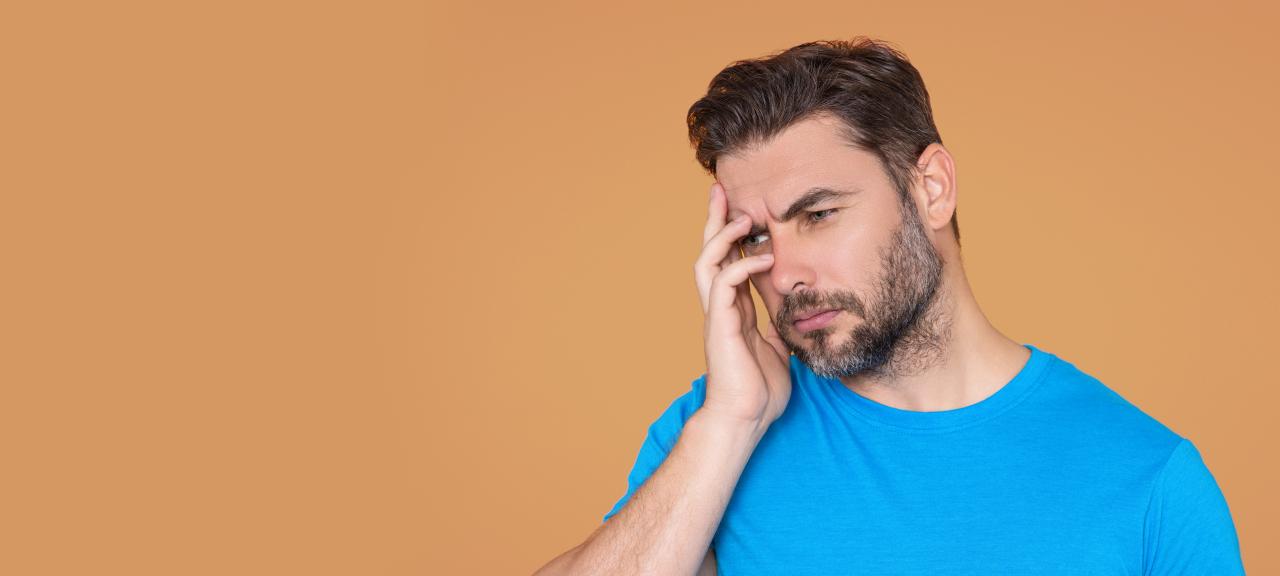 Homem com a mão sobre a cabeça representando alguém cansado ou estressado