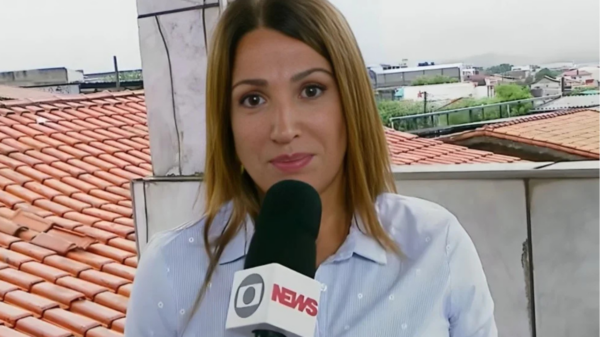 Apresentadora Ananda Apple posa para foto em estúdio de televisão, com expressão confiante e aparência profissional.