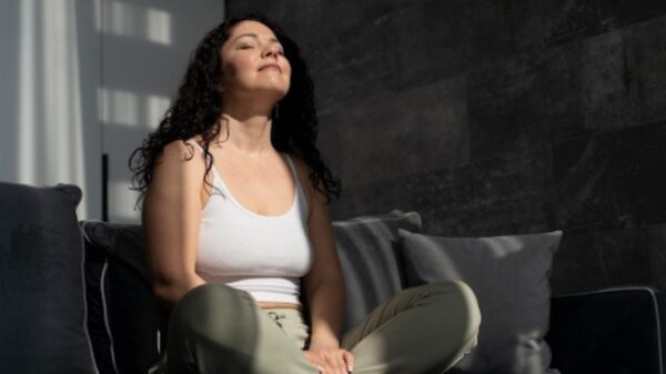 Mulher sentada no chão olhando para o alto com sensação de relaxamento.