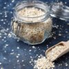 Psyllium num pote de vidro aberto em cima de uma mesa de mármore.