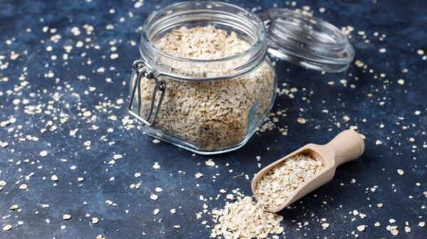 Psyllium num pote de vidro aberto em cima de uma mesa de mármore.