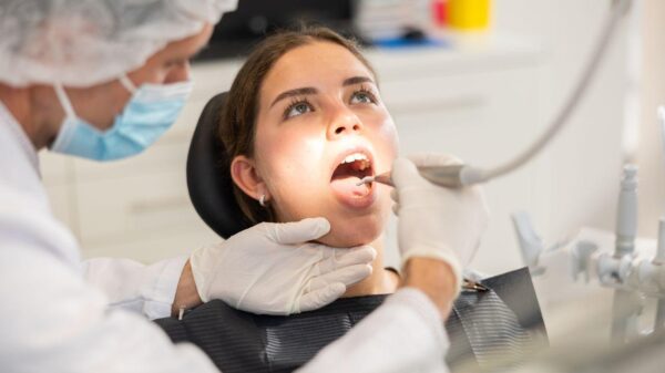 Mulher com a boca aberta em exame no dentista.