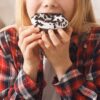 Imagem de uma criança comendo um donuts
