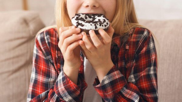 Imagem de uma criança comendo um donuts