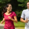 Homem e mulher correndo juntos no parque, exercícios físicos são aliados na prevenção da demência