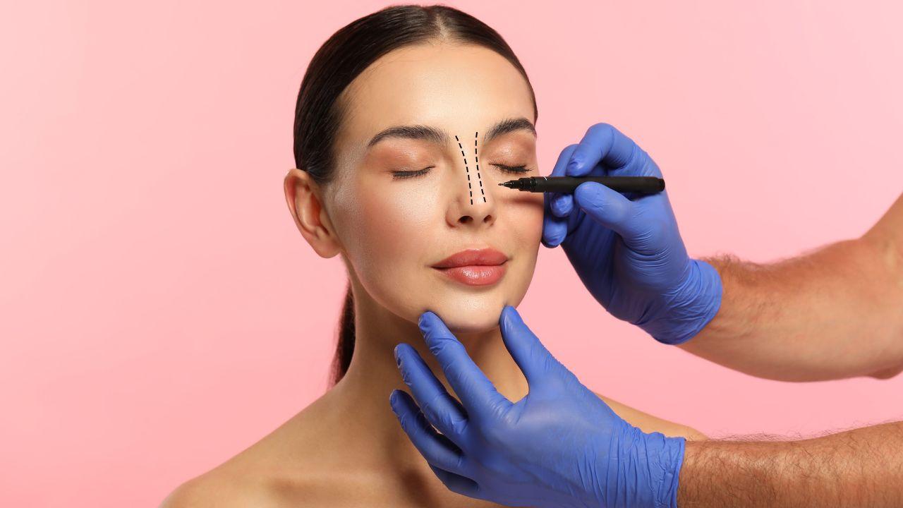 Imagem de uma mulher com o nariz com marcas de caneta feitas por uma mão enluvada