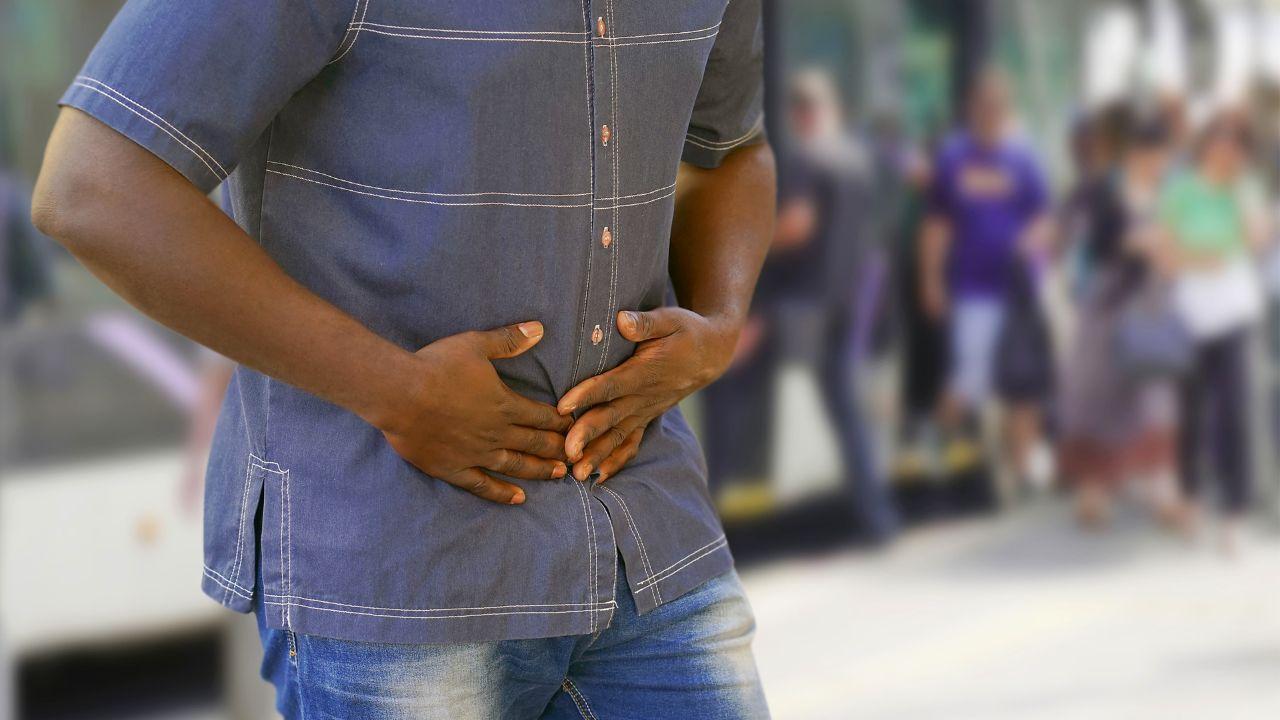 Imagem de um homem com a mão na barriga (na região do intestino)