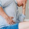 Imagem de um homem com a mão na região do ventre, sofrendo com gastroenterite