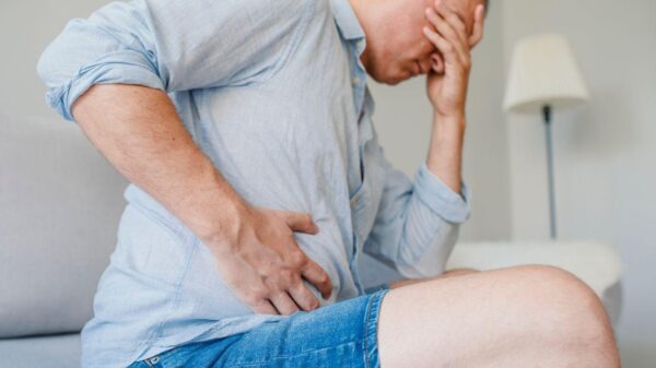 Imagem de um homem com a mão na região do ventre, sofrendo com gastroenterite