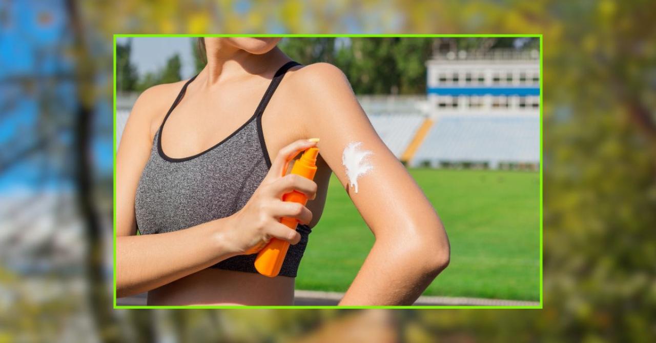 Mulher jovem aplicando protetor solar no braço ao ar livre