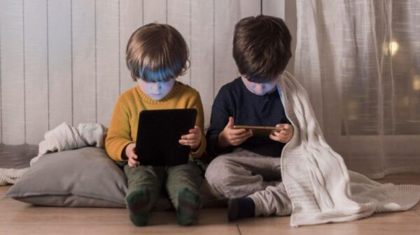 Imagem de duas crianças utilizando celular