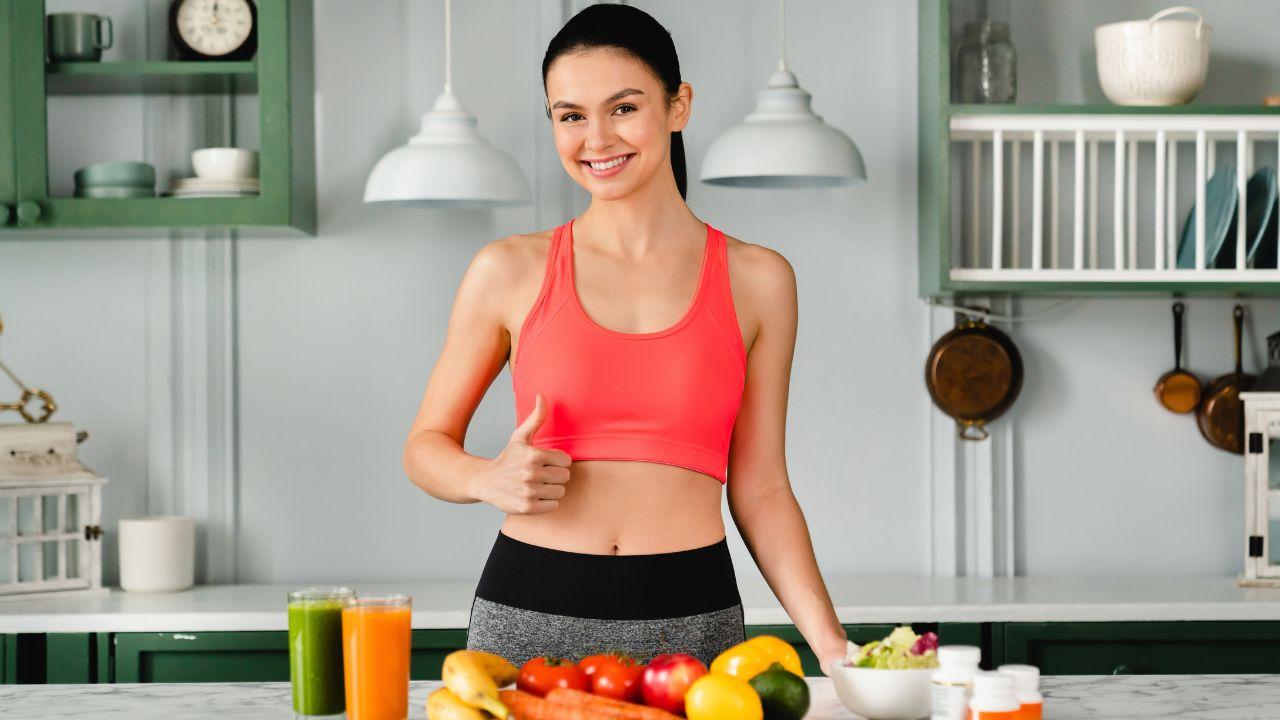 Mulher na frente da mesa com frutas e legumes.