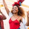Imagem de duas mulheres e um homem sorrindo pulando Carnaval