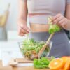 Imagem de uma mulher preparando uma salada