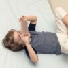 Criança usando dispositivo móvel em casa ilustra discussão sobre uso de telas na infância após novo guia da Academia Americana de Pediatria.
