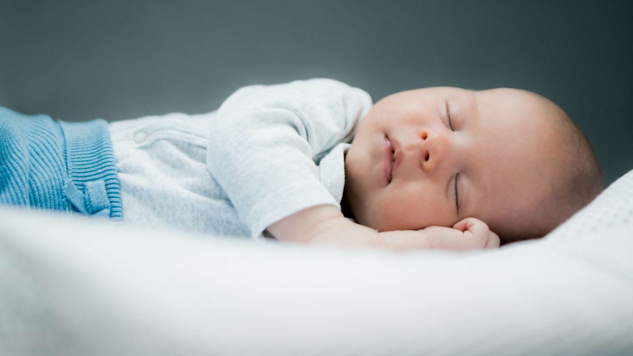 Imagem de um bebê deitado de lado dormindo