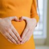 Imagem de uma mulher fazendo coração na barriga