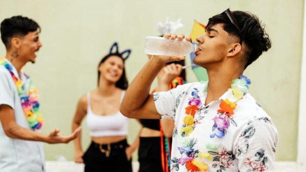 Imagem de um homem tomando água em um bloquinho de Carnaval