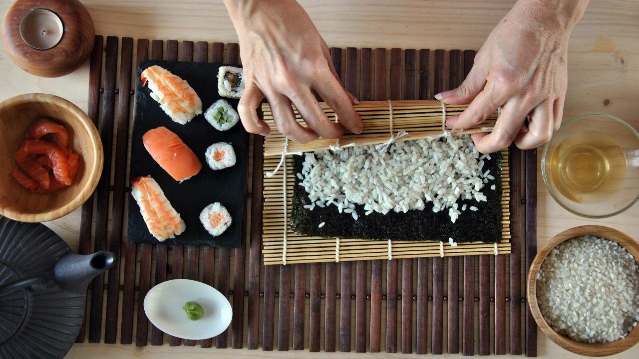 Imagem de uma pessoa montando um sushi