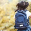 Imagem de uma criança usando uma mochila azul escura