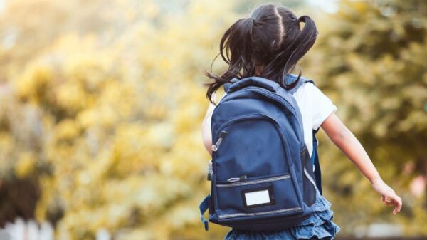 Imagem de uma criança usando uma mochila azul escura