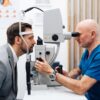 Homem fazendo exame de vista com o médico oftalmologista. É o exame que a pessoa senta e o médico vê o olho do paciente.