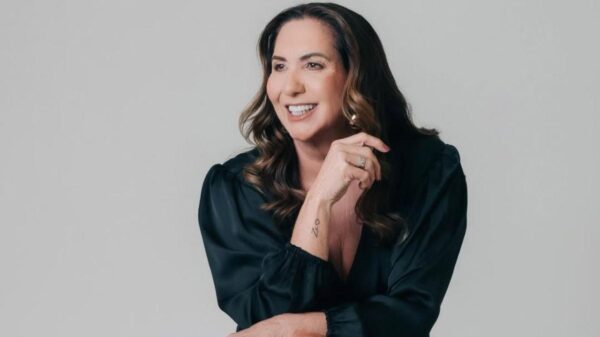 Margareth Serrão. Mulher branca, cabelo castanho, curto, usando vestido preto e maquiada.