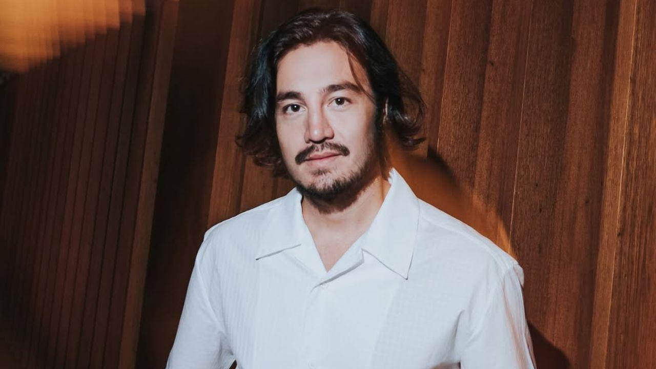 Cantor Tiago Iorc. Homem branco, cabelo preto curto, barba e camisa branca.