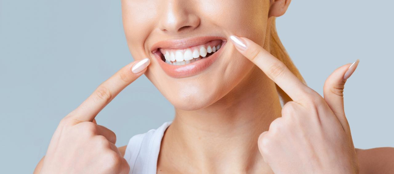 Mulher mostrando os dentes bem brancos.
