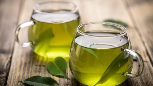 Foto mostra xícaras transparentes de chá verde.