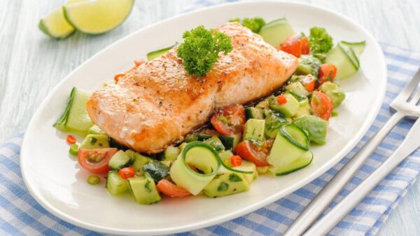 Imagem de um peixe cozido em um prato com legumes