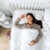 Imagem de uma mulher deitada de costas na cama