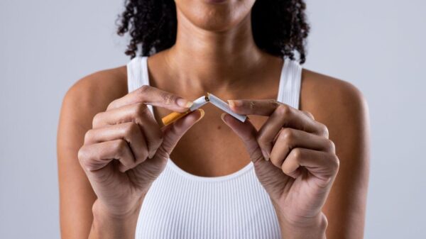 Imagem de uma mulher quebrando um cigarro ao meio