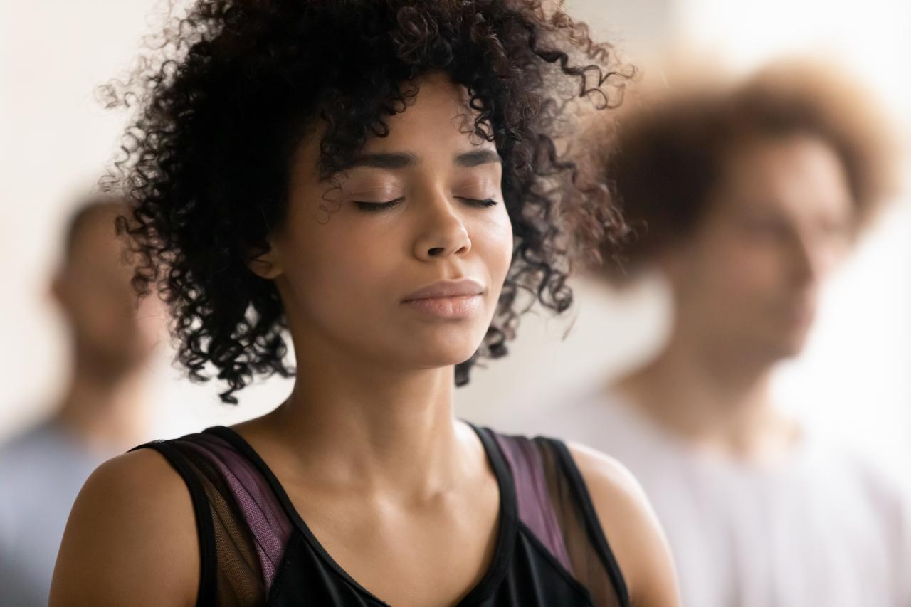 Mulher negra com os olhos fechados em silêncio.