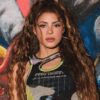 Shakira. Mulher latina, cabelo cacheado longo, com cropped.