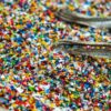 Foto mostra um saco de cheio de microplásticos coloridos.