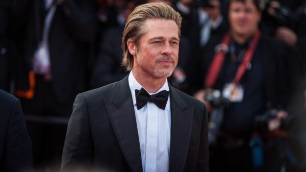 Foto mostra o ator Brad Pitt em premiação. Homem branco, loiro, cabelo curto, usando terno preto.