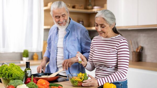 Imagem de um casal de idosos cozinhando juntos