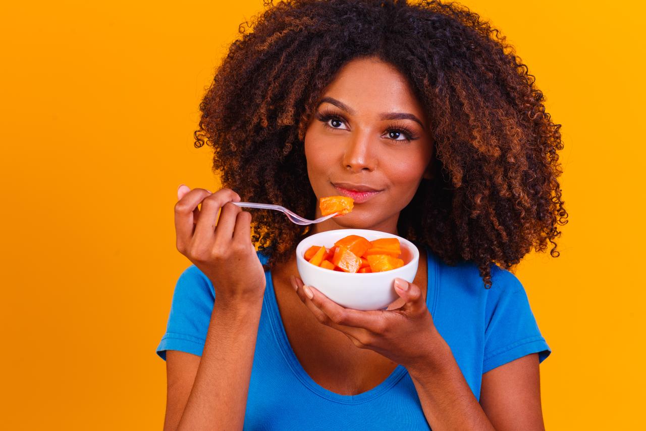 mulher comendo Mamão