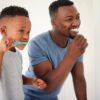Pai e filho escovando os dentes