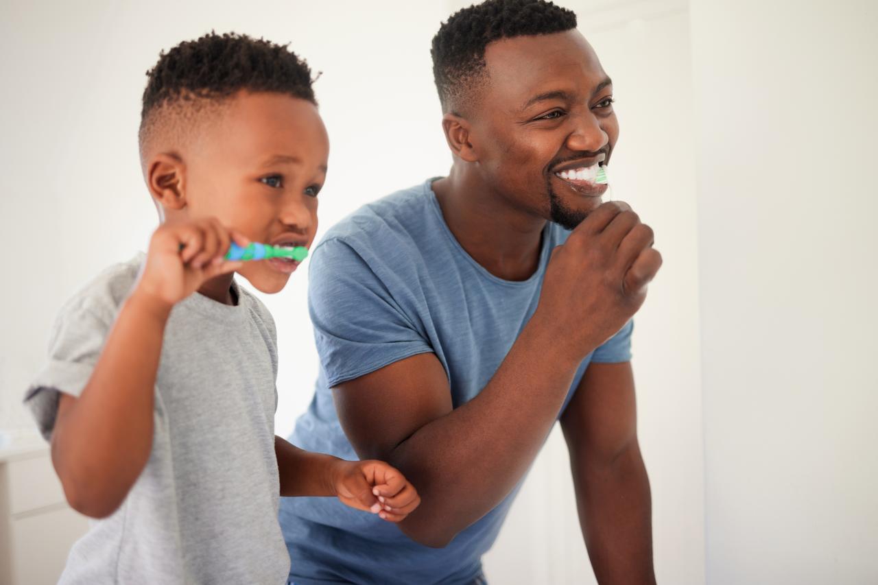 Pai e filho escovando os dentes