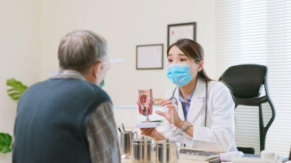Imagem de uma médica consultando um paciente homem idoso