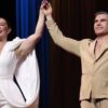 Mostra Claudia Raia e o marido Jarbas Homem de Mello juntos no palco com as mãos unidas pra frente.
