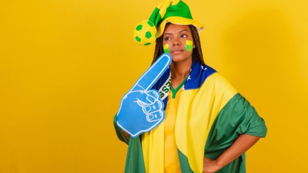 Mulher com roupa da seleção brasileira torcendo pelo Brasil.