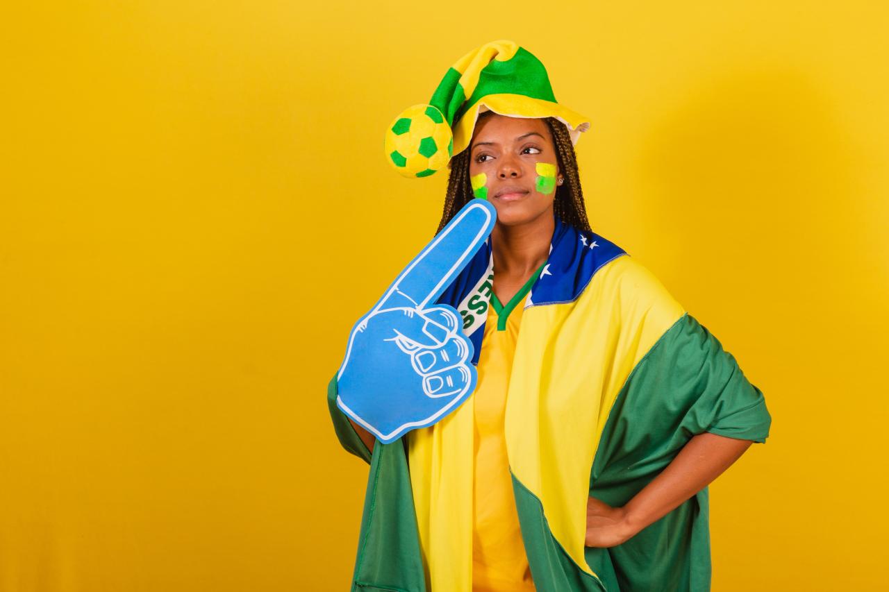 Mulher com roupa da seleção brasileira torcendo pelo Brasil.