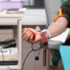 Foto mostra pessoa doando sangue.