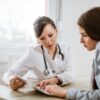 Mulher conversando com a médica no consultório médico.