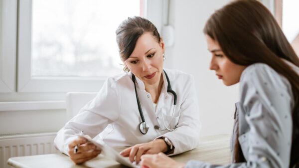 Mulher conversando com a médica no consultório médico.