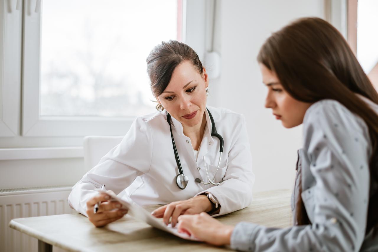 Mulher conversando com a médica no consultório médico.